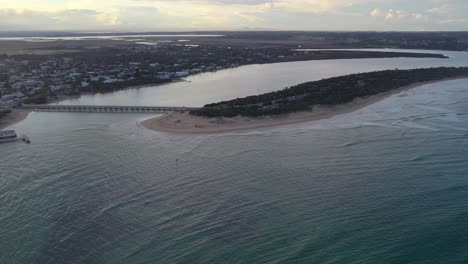 Imágenes-Aéreas-Inversas-Que-Miran-Río-Arriba-Cerca-De-La-Desembocadura-Del-Río-Barwon-En-Las-Cabezas-De-Barwon-Con-El-Lago-Connewarre-En-El-Fondo,-Victoria,-Australia