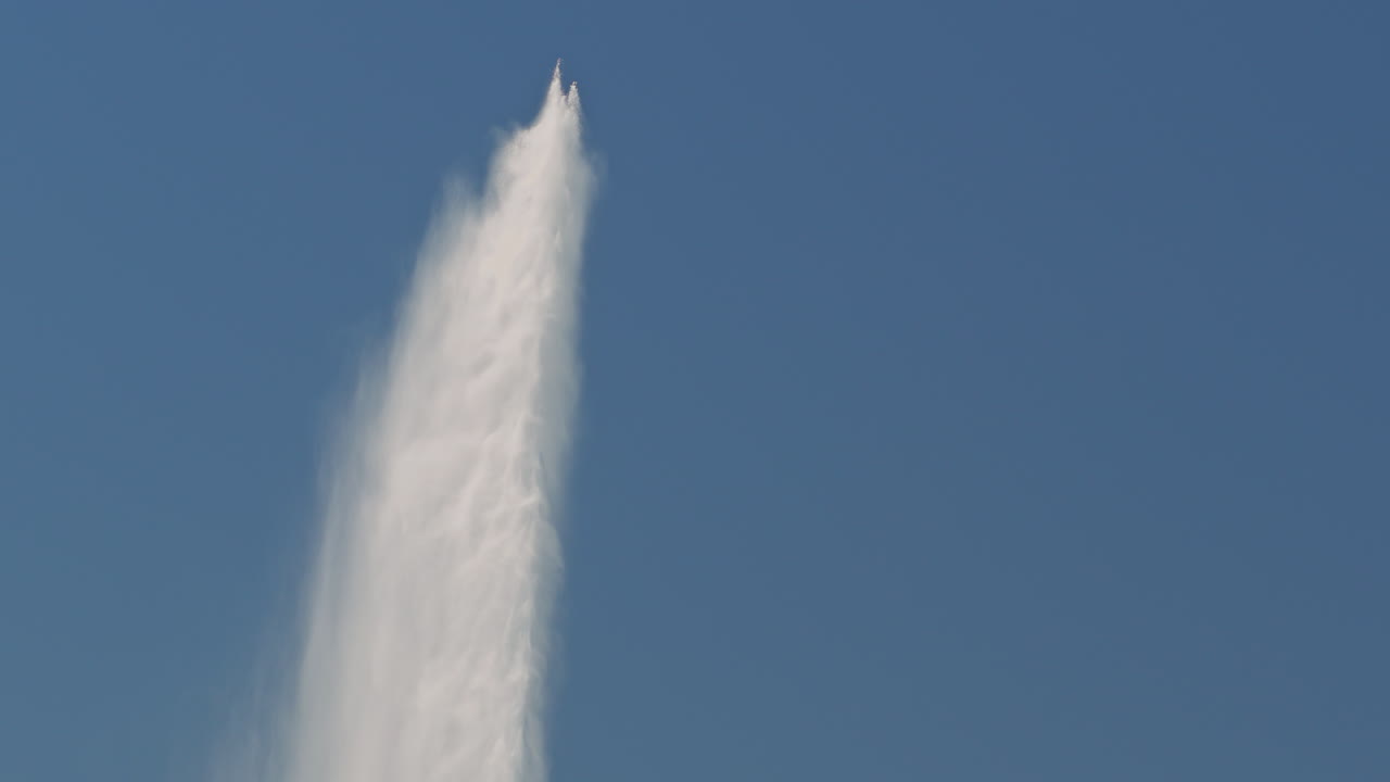 Peaceful morning in Geneva with the iconic Jet d’Eau rising from the lake, calm waters reflecting the clear sky, and the city slowly coming to life in the morning light.