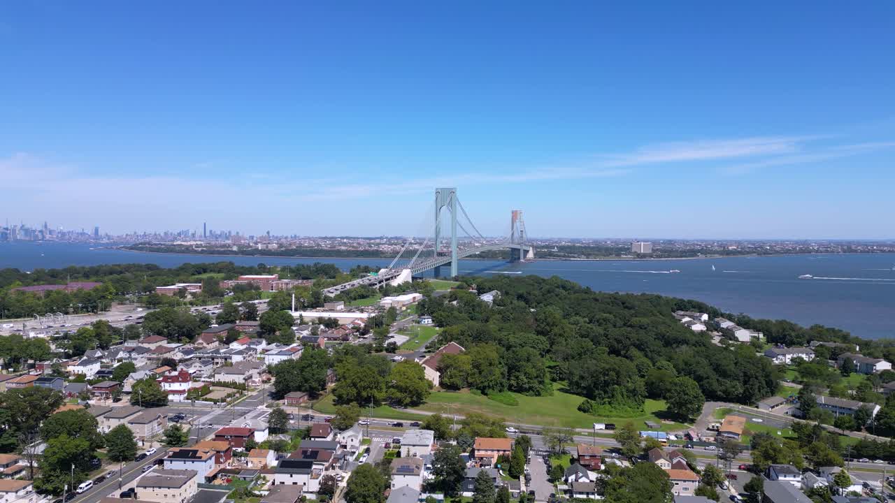Stunning aerial view of Staten Island and the Verrazzano-Narrows Bridge with a clear skyline, waterfront, and residential neighborhoods under a bright blue sky