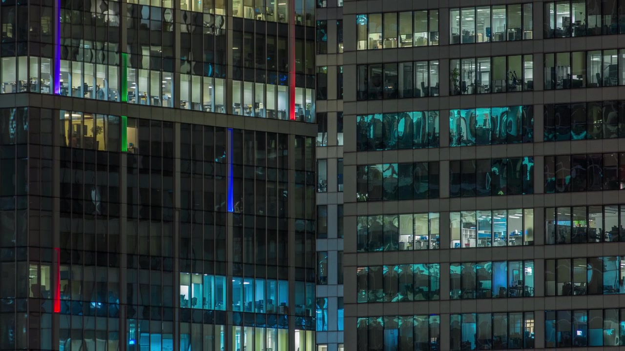 Vista de perto das janelas panorâmicas de escritórios nos arranha-céus do International Business Center da Cidade à noite, timelapse do alto.