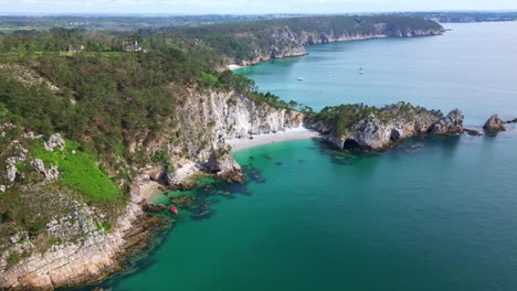 descending drone movement near the virgin island beach dramatic cliff coastline side with dense forest and turquoise sea, crozon peninsula, brittany, france