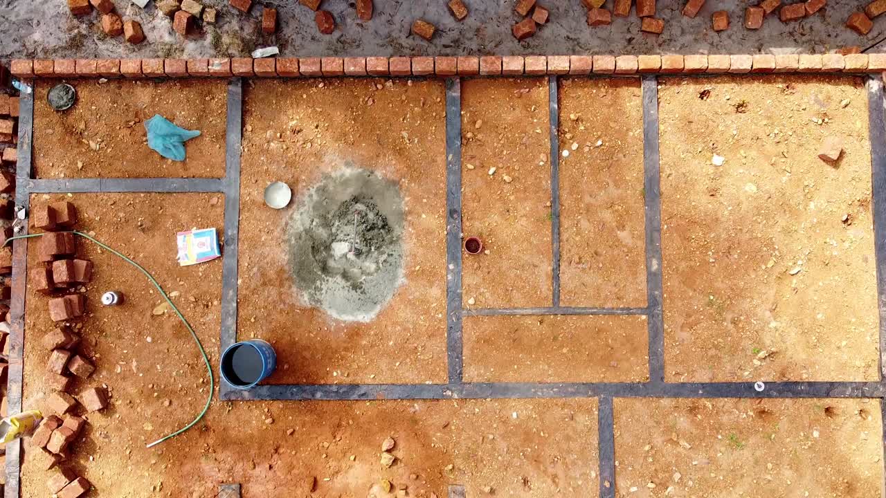 la fundación de la casa está llena de construcción de tierra usando bloques de barro, los trabajadores trabajan en un sitio de construcción en la india, construyendo una casa con piedra roja, trabaja usando cemento