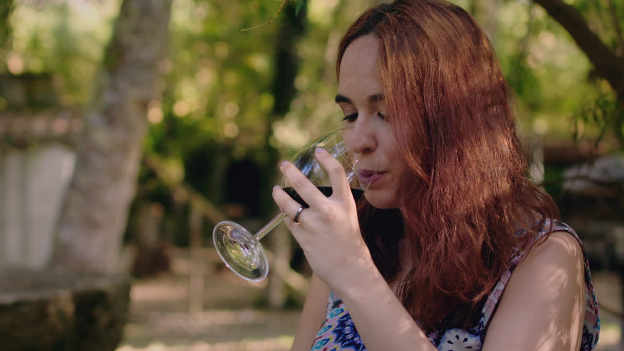 chica prueba un vaso de vino en un parque de picnic medio tiro