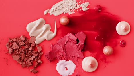 makeup swatches and spills on a red background