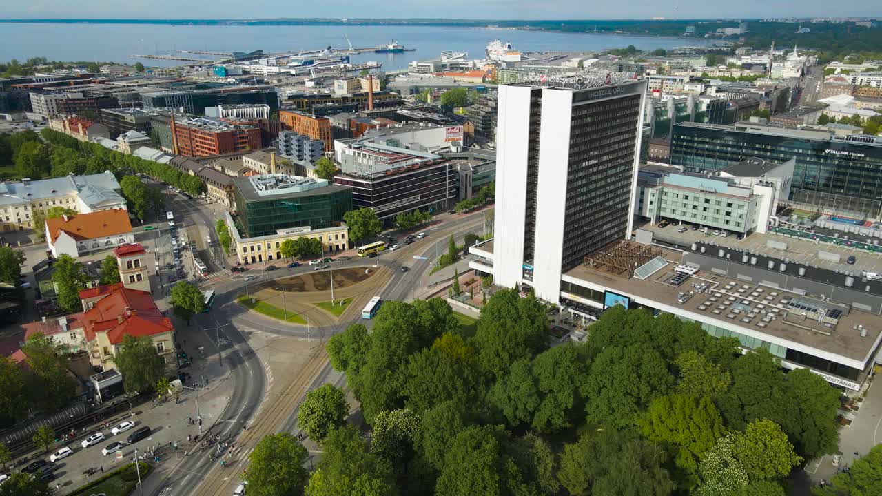 Overlooking view of Tallinn city center, Hotel Viru and vibrant city roundabout. Expansive view revealing Viru Square, historic buildings and modern developments, harbor in distance. Beautiful weather