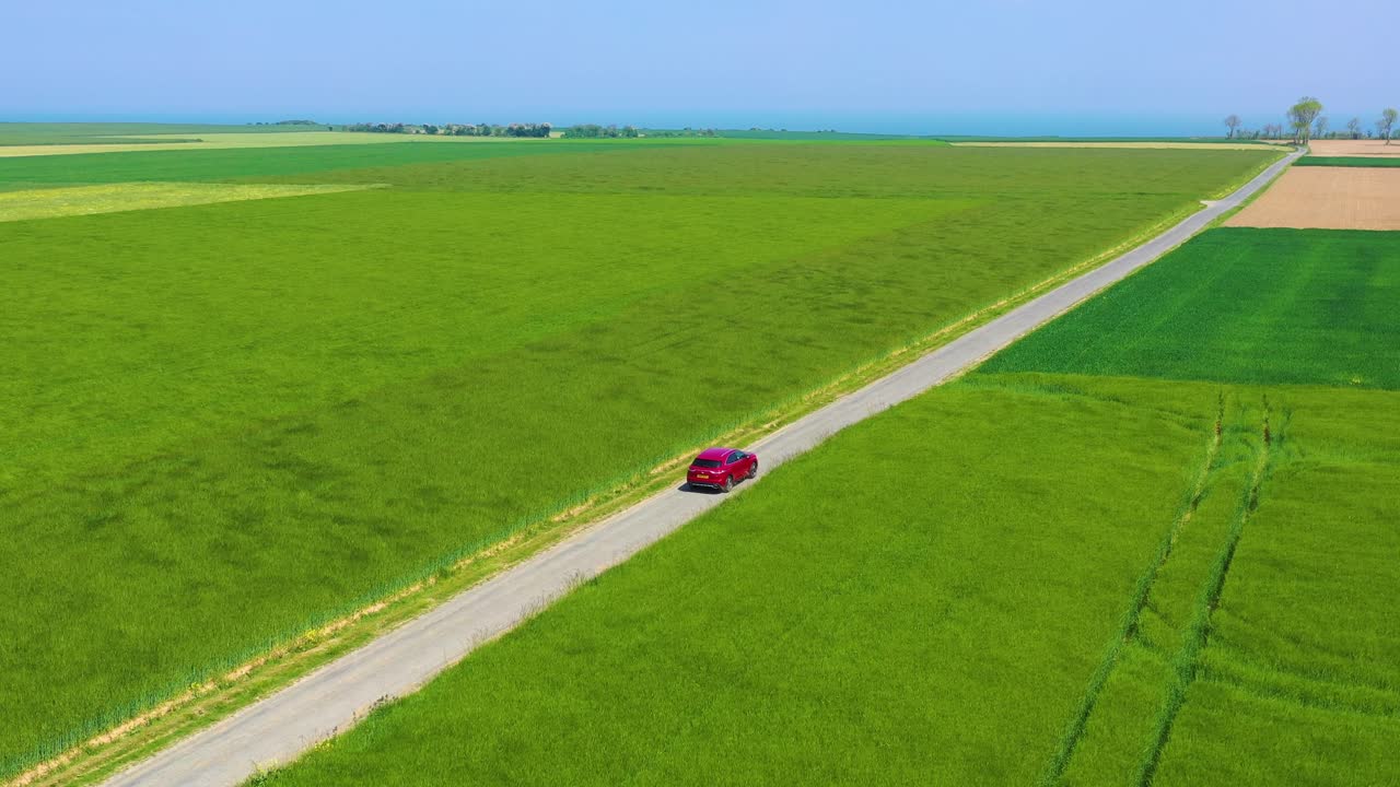 노르망디 프랑스의 푸른 들판을 여행하는 빨간 자동차의 공중