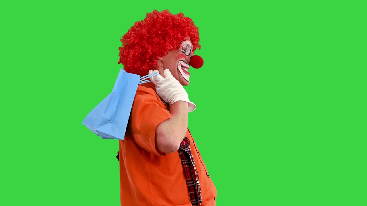payaso gracioso en un paseo con bolsas de compras en una pantalla verde, clave de croma