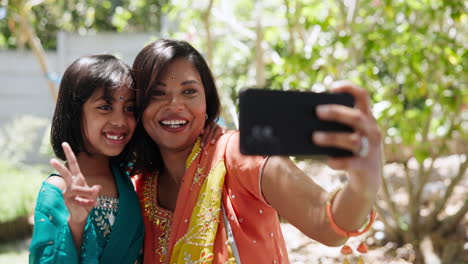 mother and daughter taking a selfie in traditional attire