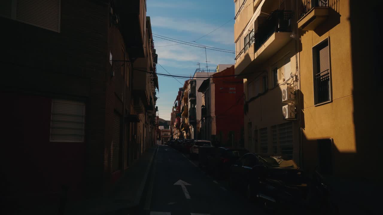 Viela Residencial Estreita com Carros Estacionados e Luz Quente