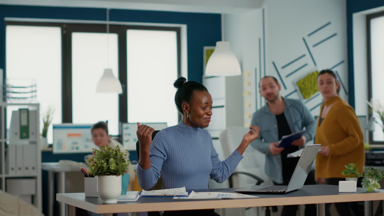 Smiling successful employee with great work results receiving congratulations from coworkers