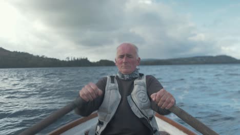 fisherman rowing on rough lake real time