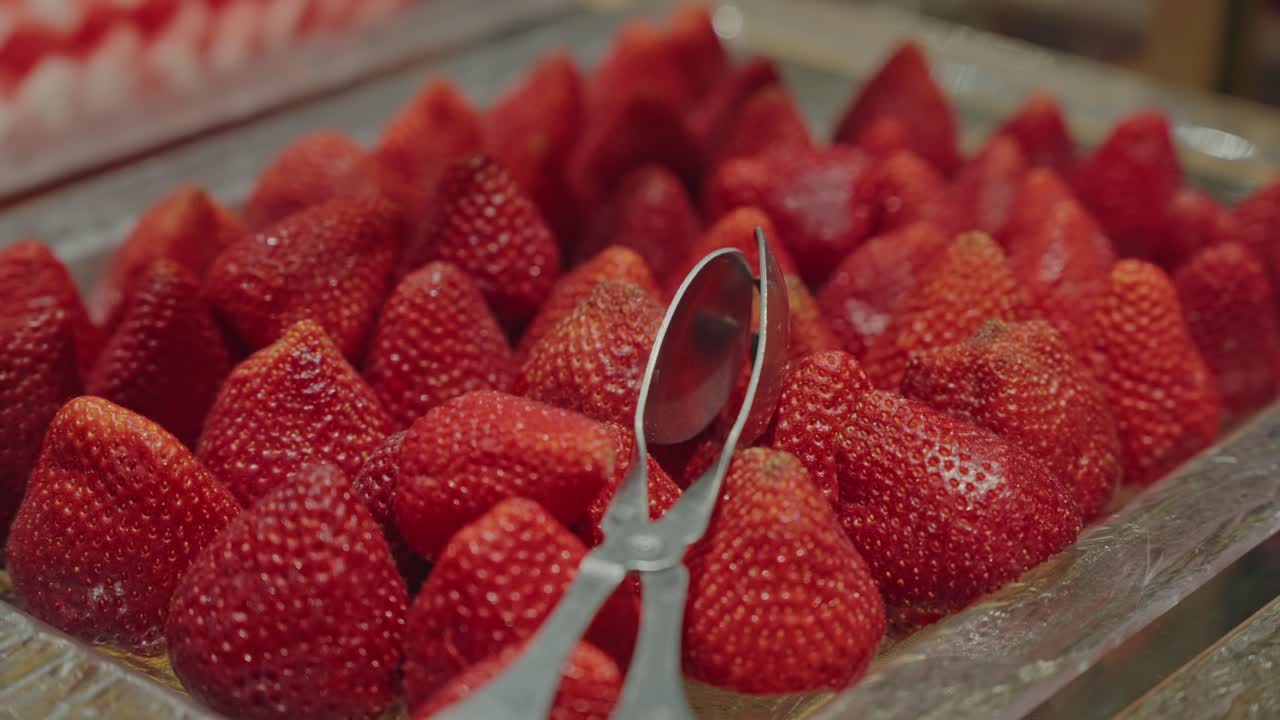 Ripe red strawberries neatly arranged on a buffet fruit display