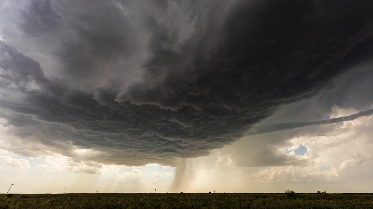 Severe weather clouds building over open landscape before rainstorm