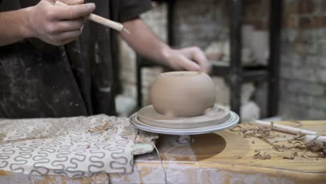 artisan potter shaping a bowl on a pottery wheel