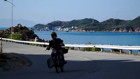 young man drives motorcycle near binh hung island with fisheries, fishing farms and fishing nets behind