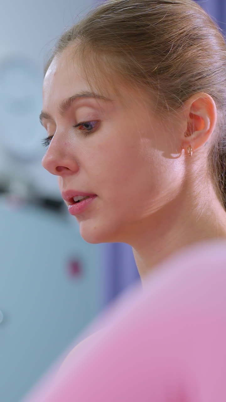 primer plano de una mujer haciendo ejercicio con un amigo conversando cerca en un gimnasio con un diseño interior elegante, que refleja un entorno de fitness amistoso y de apoyo