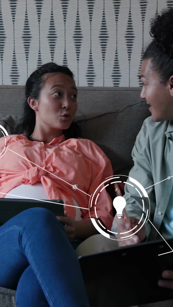 Vertical video: Woman holding tablet on sofa, overlay bulb icons appearing and guiding tech chat