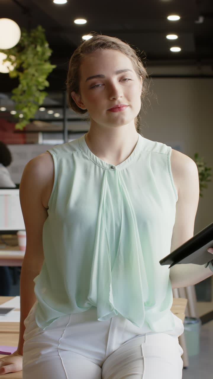 Vertical video of portrait of happy caucasian businesswoman with tablet in slow motion
