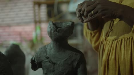 close-up of hands sculpting a clay figure, highlighting the art of craftsmanship and creativity