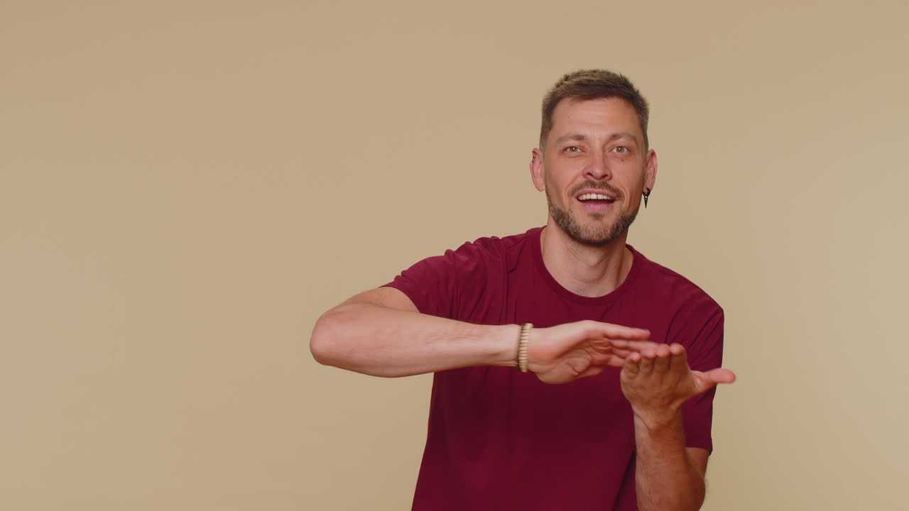 joven guapo barbudo mostrando desperdiciar o lanzar dinero alrededor de gesto de la mano, más propinas ganancias