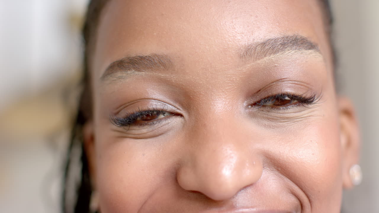 joven afroamericana con rostro sonriente, con maquillaje