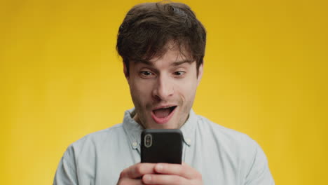 man excitedly reading a message on phone