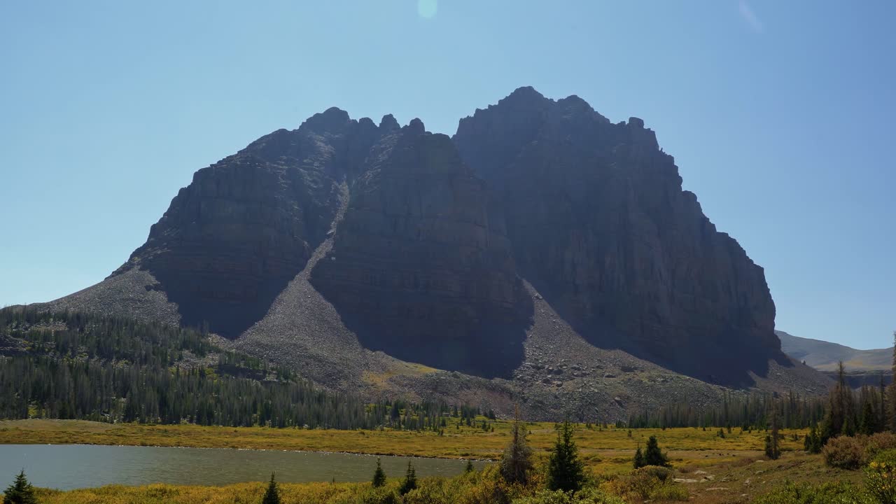 impresionante paisaje natural inclinado hacia abajo del increíble pico del castillo rojo en un sendero para mochileros en el bosque nacional high uinta entre utah y wyoming con un lago de pesca a la izquierda.