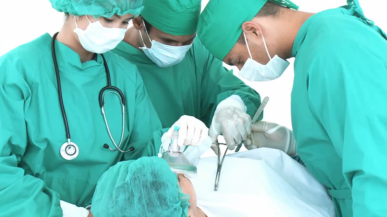 tres cirujanos operando a un paciente