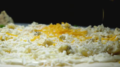 preparando una pizza con varios quesos