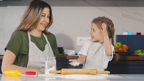 Hija-Juega-Con-Harina-Cocinando-Con-Madre-Joven-En-La-Mesa