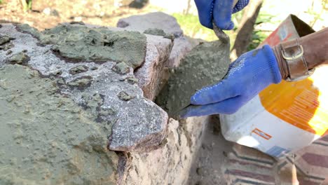 Hombre-Latino-Albañil-Pegando-Piedras-Con-Cemento