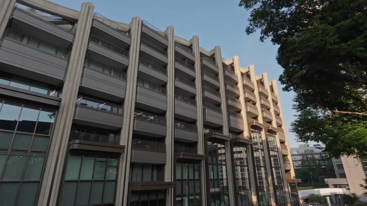 A contemporary building in Tokyo featuring a unique facade with multiple balconies and large windows.