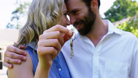 cute couple looking each other and holding keys