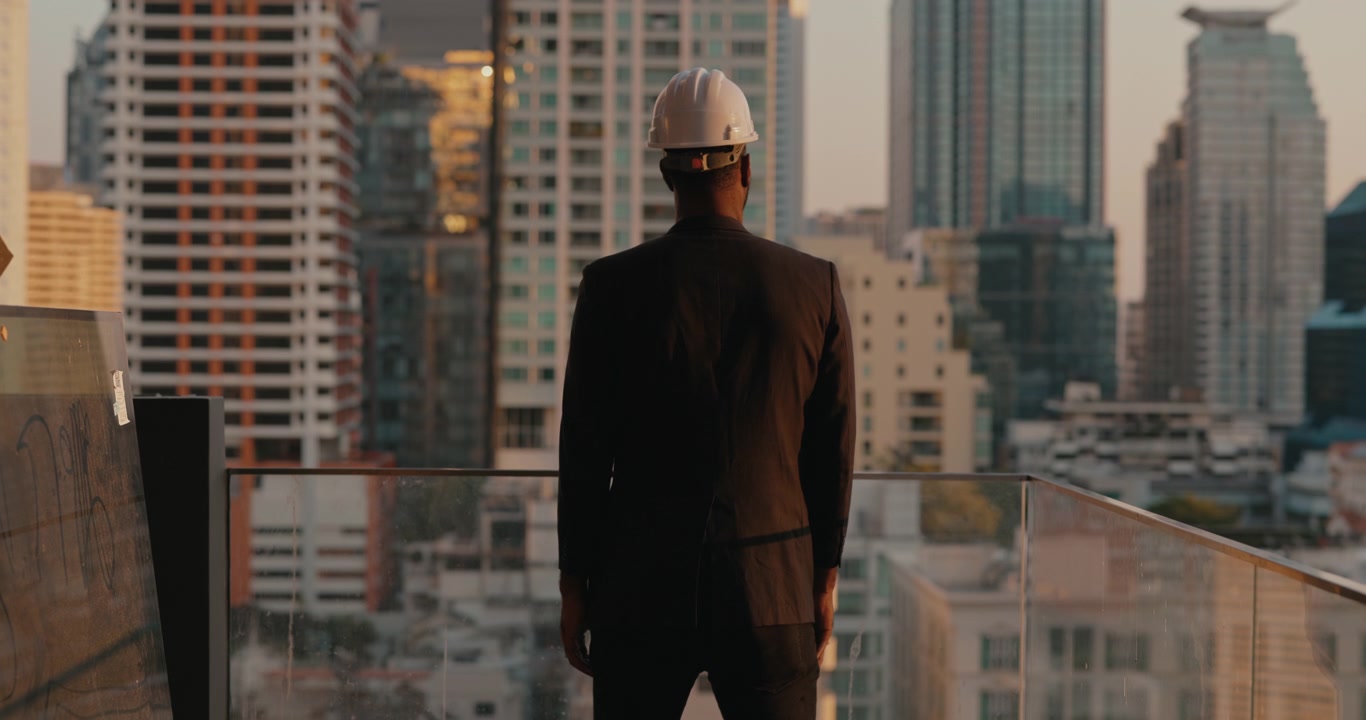 Arquitecto con sombrero mirando el horizonte de la ciudad