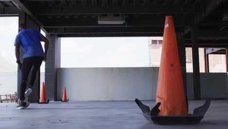 Hombre-Afroamericano-Haciendo-Trucos-Con-Una-Pelota-De-Fútbol-En-Un-Edificio-Urbano-Vacío