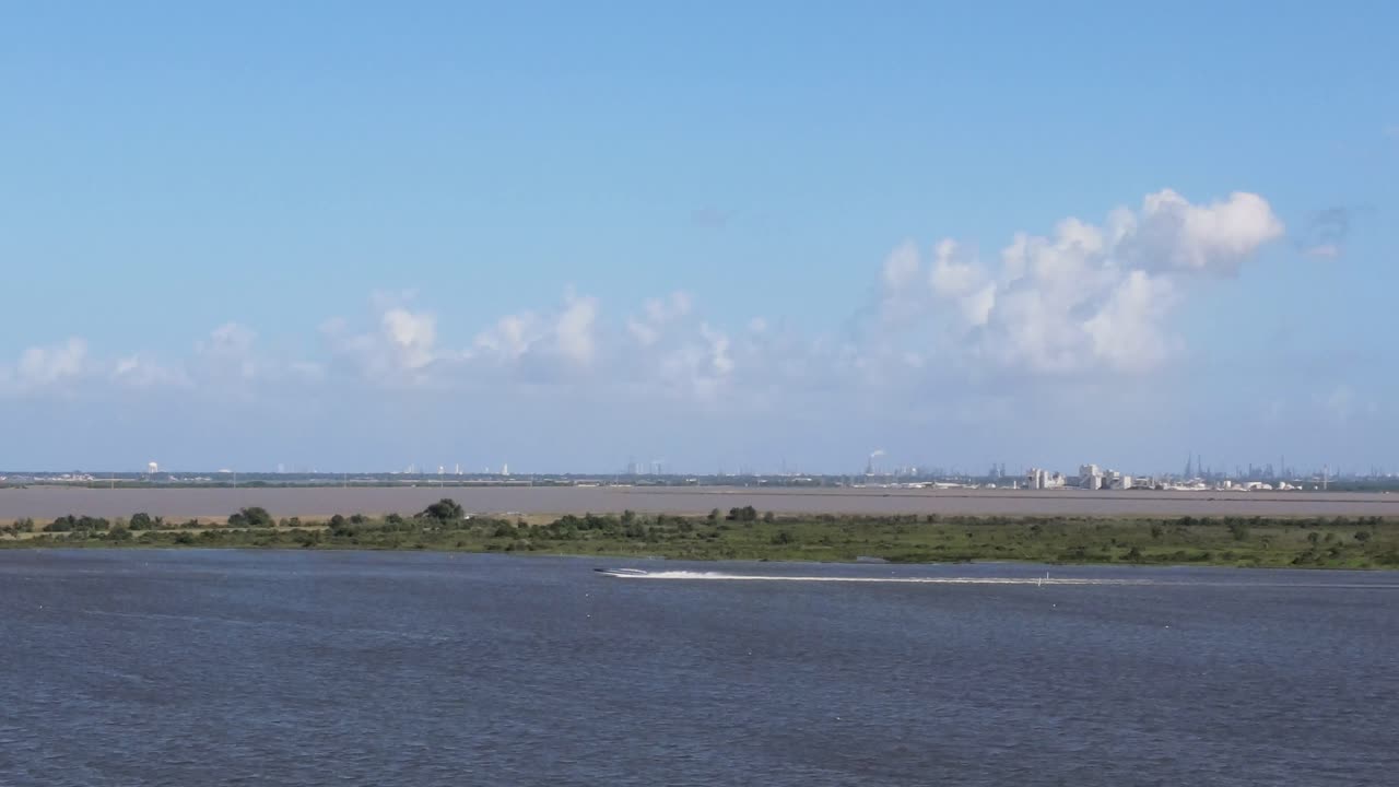 Boat on an industrial waterway with a distant skyline
