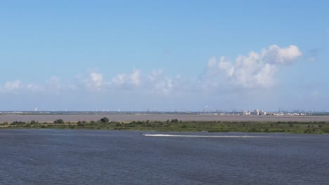 boat on an industrial waterway with a distant skyline