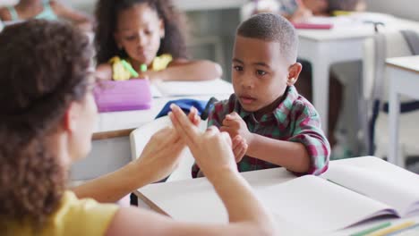 Video-Einer-Glücklichen-Kaukasischen-Lehrerin,-Die-Einem-Afroamerikanischen-Jungen-Mathematik-Lernt