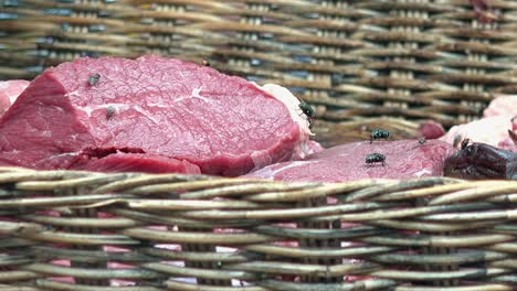 flies on raw beef in a basket for sale at the market