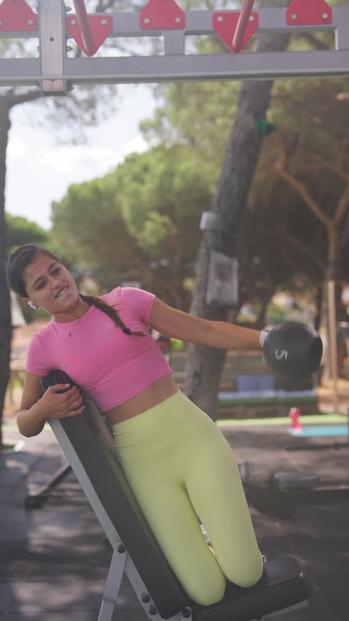 Woman Exercising with Dumbbell at Outdoor Gym