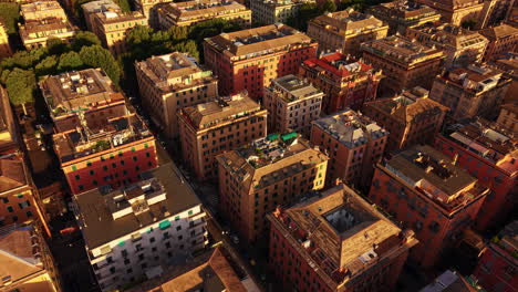 drone descends in forward motion above genoa’s colorful buildings and trees at sunset