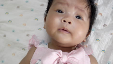 a baby girl who is several months old smiles sweetly with adorable chubby cheeks