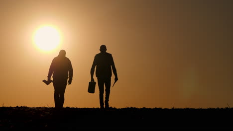 farmers walking at sunset