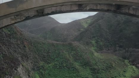 retire la vista aérea del dron que pasa por debajo cerca de la autopista del pacífico sur mientras el tráfico pasa por encima