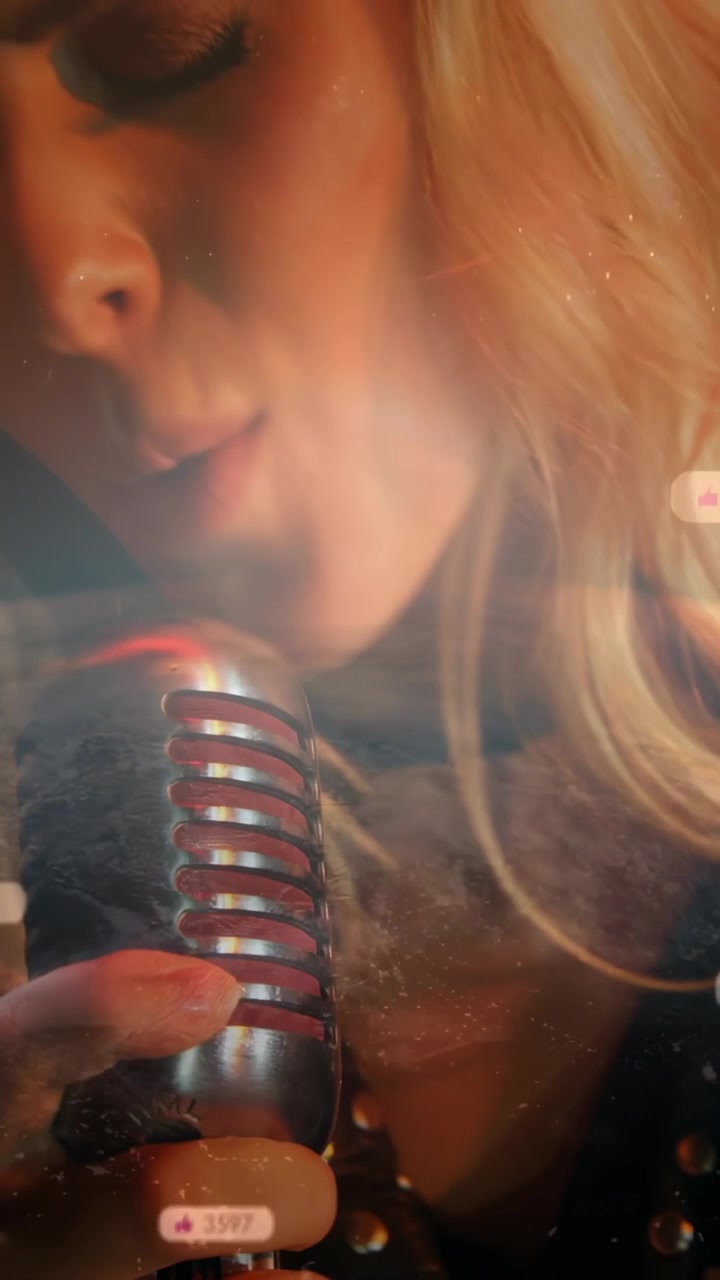 Vertical video: Music singer leaning into mic, singing and generating bubbles, seeking likes