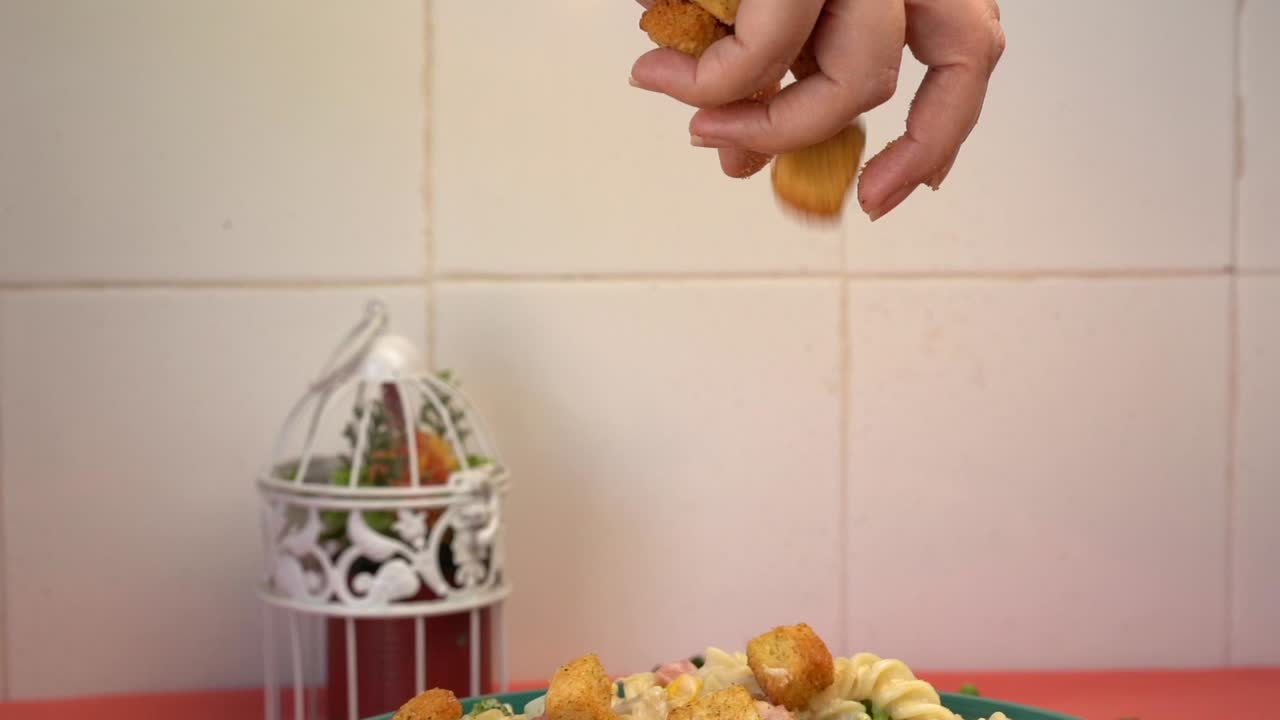 agregar a mano picatostes a la pasta en cámara lenta