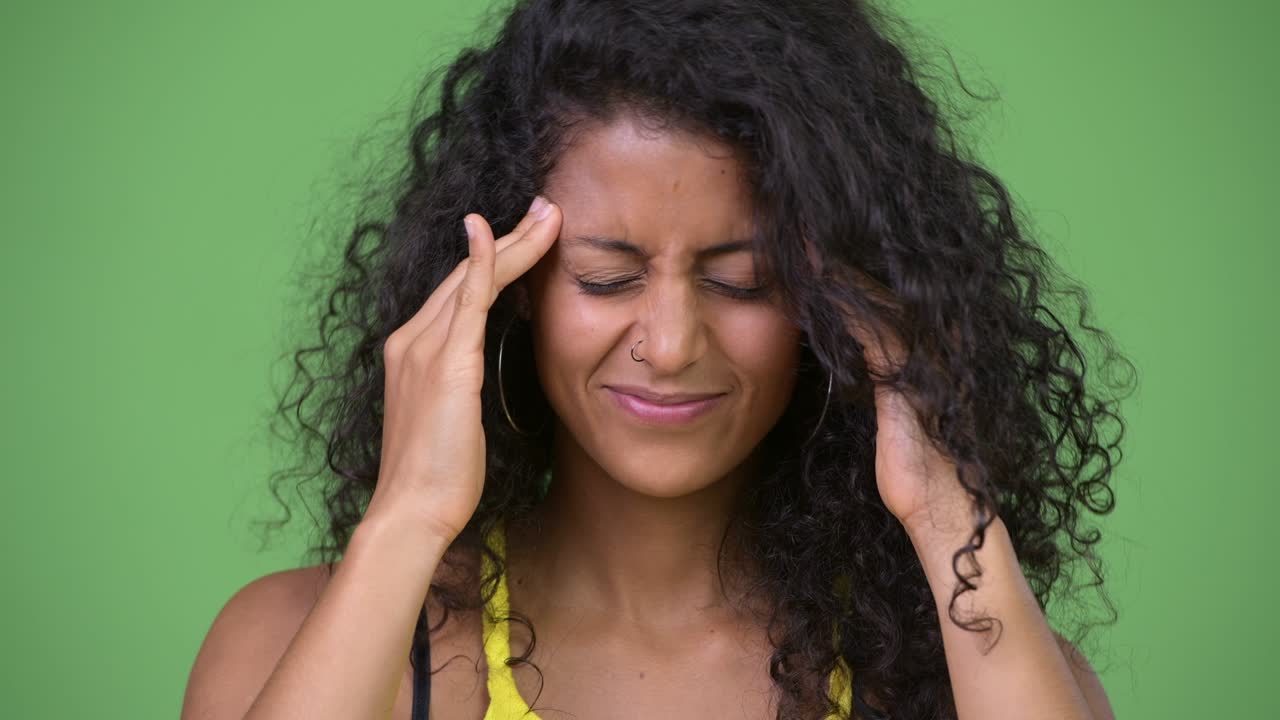 Young beautiful Hispanic woman having headache