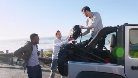 Tres-Amigos-Varones-Adultos-Jóvenes-Descargando-Mochilas-Del-Jeep