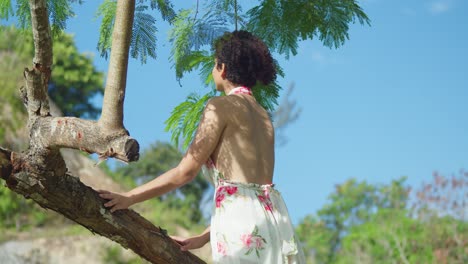 low angle of a young red curly hair latina at the park with blue skies in the background