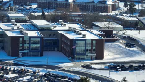 aerial wide shot of an american school campus covered in snow